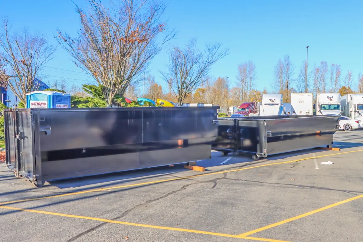 Professional dumpster rental service with roll-off container on residential driveway in Robertsdale